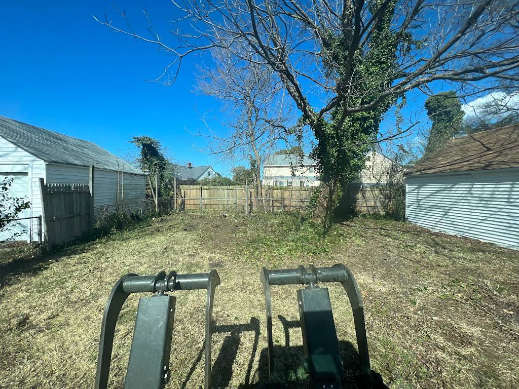 Cleared residential lot with equipment showing completed tree removal work